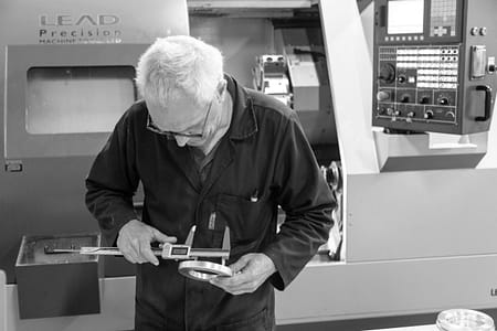 CNC engineer checking tolerances with a vernier gauge